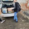 Uczniowie pakują paczki do samochodu